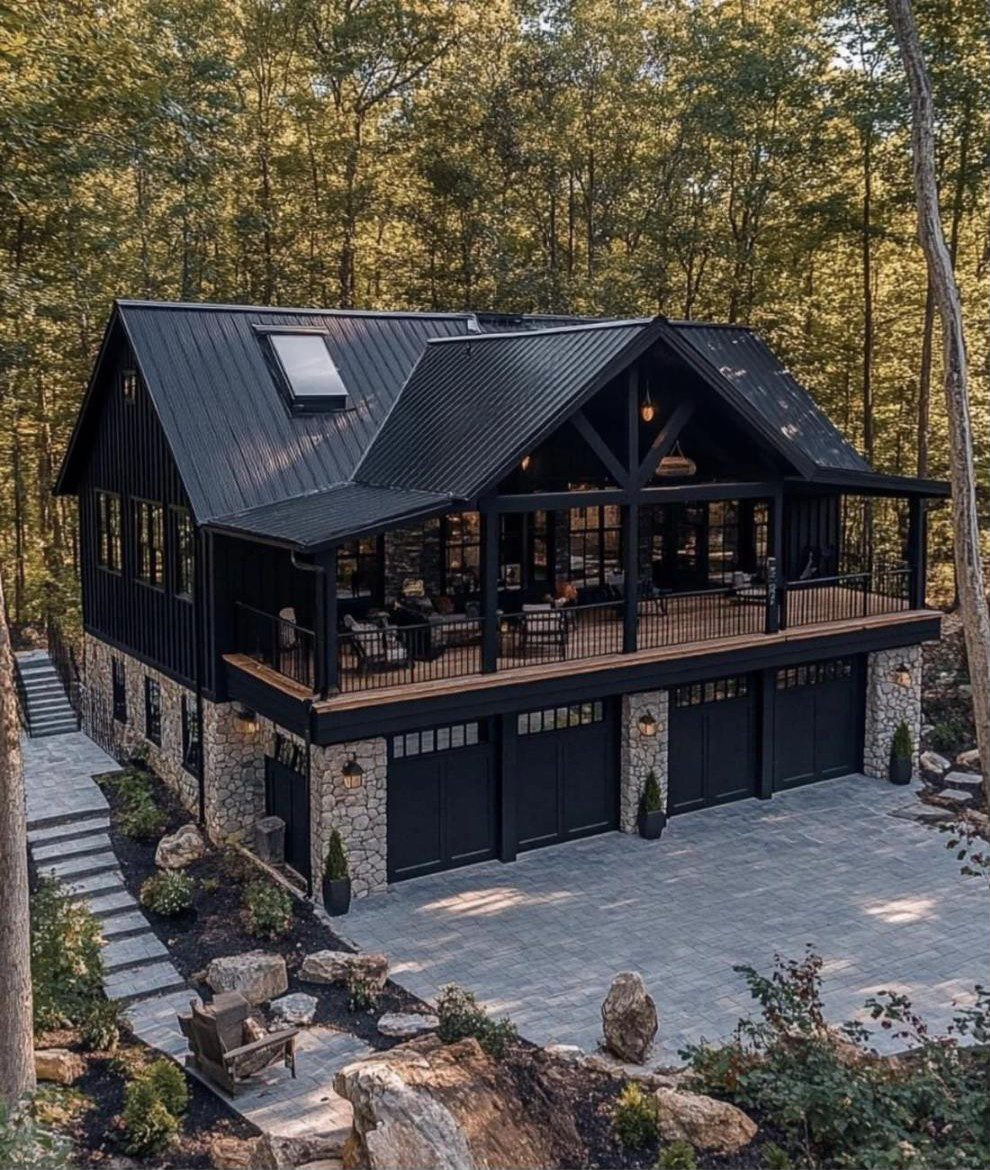 Modern black farmhouse with a stone garage level and a wide upper deck